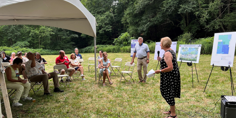person speaking outdoors with microphone
