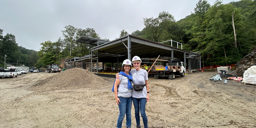 two people in hard hats in front of steel girders